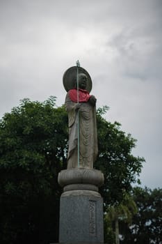 Singapore - July 9 2023: Stone Monk Statue With Red Scarf