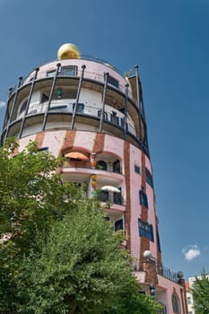 View of the tower of the famous Hundertwasserhaus, the last building by the architect Friedensreich Hundertwasser, in the city center of Magdeburg in Germany