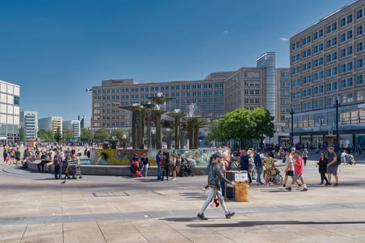 People at the fountain on Alexanderplatz, a popular meeting place in the german capital Berlin