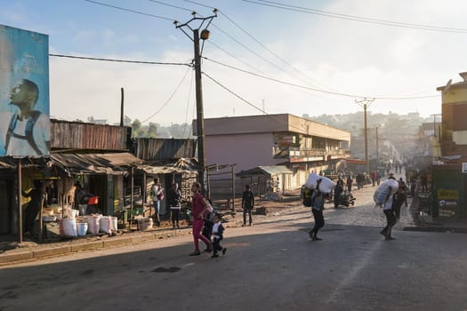 Fianarantsoa, Madagascar - May 06, 2019: Typical morning in capital of Haute Matsiatra Region. People setting up their stalls for market, walking on the street, haze in distance predicts hot day
