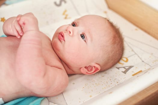 4 months old infant baby boy at changing table, detail on his head