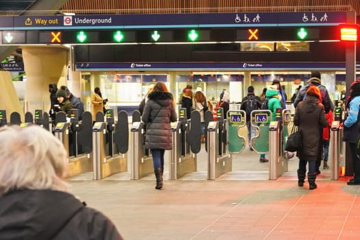 London, United Kingdom - February 01, 2019: People walking through turnstile at London Bridge underground station - 4th busiest in UK capital - ticket offices in background