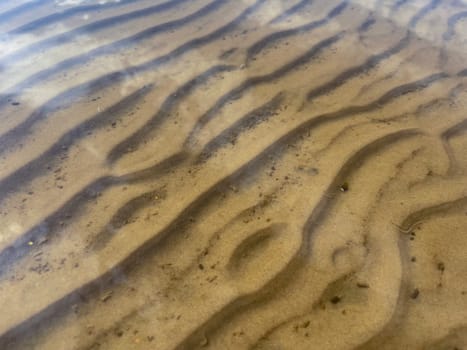 in summer, there are traces left by the surf on the sand at the bottom of the river