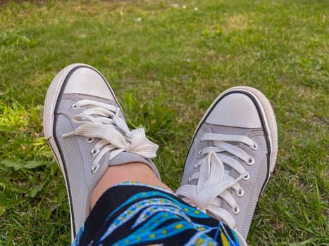 summer grey sneakers on the green grass in summer