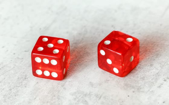 Two translucent red craps dices on white board showing Natural or Seven Out (number 5 and 2)