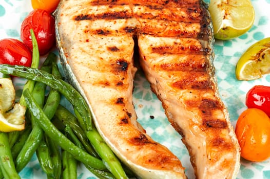 Roasted salmon garnished with potatoes and green beans. Grilled fish.