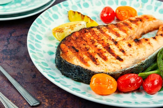 Roasted salmon garnished with potatoes and green beans. Grilled fish.
