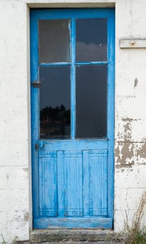 old house white wall with a blue door