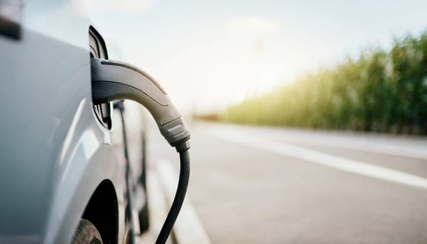 Charging an electric car in the city, closeup of a charging cable. AI generated