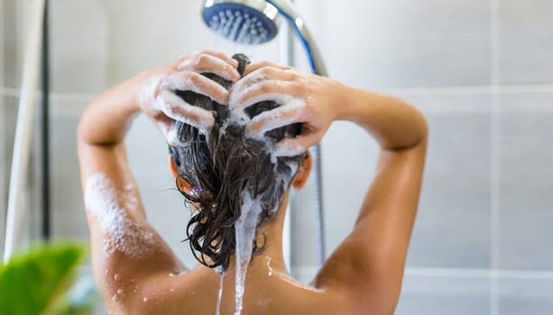 Woman washing his hair in the shower, close-up, rear view. AI generated
