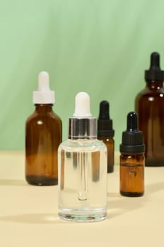 Glass bottles for cosmetics, oils with a pipette on a beige background