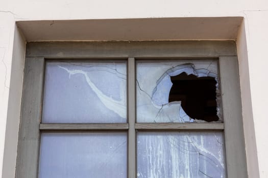 Broken glass window outside house