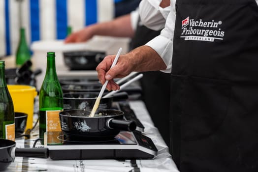September 28 2019, Charmey, Fribourg, Gruyeres, Switzerland : men are cooking the half-and-half fondue caquelons in Charmey accompanied by Swiss white wine during the transhumance festival