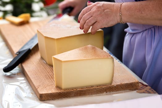 woman is saling swiss gruyere cheese in the market of Charmey, Fribourg, switzerland