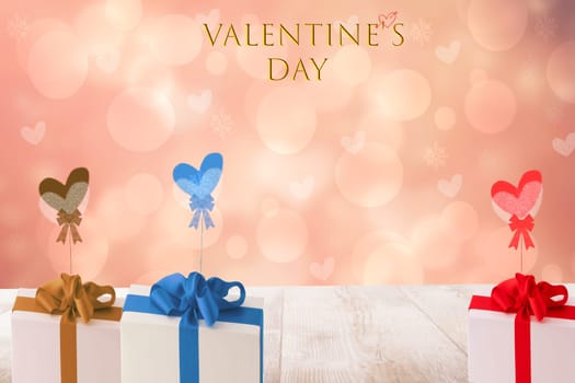 Happy Valentine's day illustration with several colored gift boxes with ribbons and bows on a bright wooden table over blurred hearts background. Card with space.