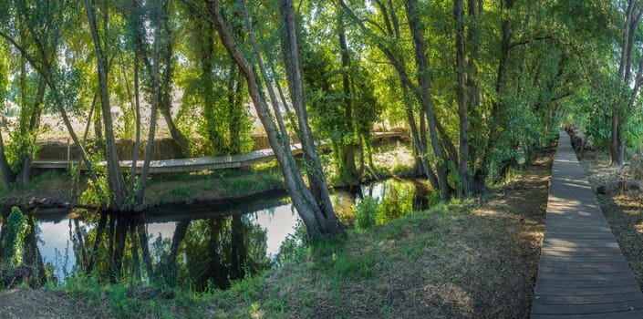 Footbridge along Gevora river, La Codosera, Badajoz, Extremadura, Spain. Idyllic location of crystal clear waters and riverside forests