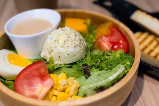 Fresh salad in the wooden bowl