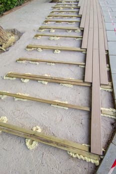 Installation of wooden flooring on a polyurethane foam base. Urban background close to public park