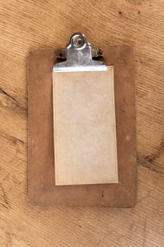 Paper note fixed with a clip on a wooden shelf