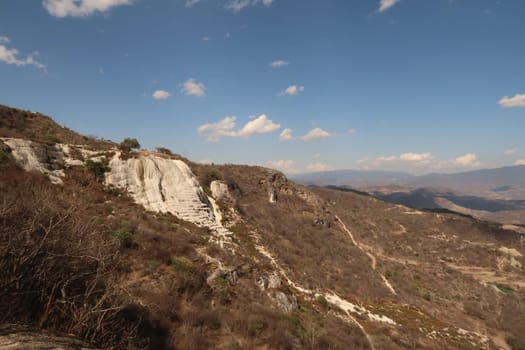 Seeing the travertine rock formations and pools of Hierve El Agua between the Oaxacan landscape from a distance, Mexico 2022