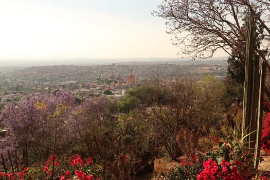 View from a view point/mirador onto the town of San Miguel de Allende with its famous church/cathedral Parroquia de San Miguel Arcangel in the middle, Mexico 2022