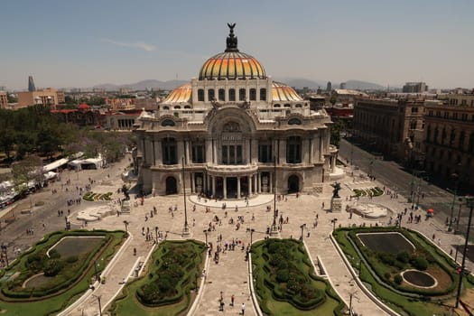 The beautiful Palacio de Bellas Artes/Palace of Fine Arts and the square and flower beds in front of it on a busy day, Mexico City 2022