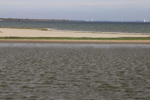 Waves with white crests inundate the sandy beach