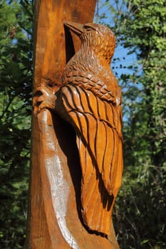 A woodpecker, carved from a tree trunk, bird