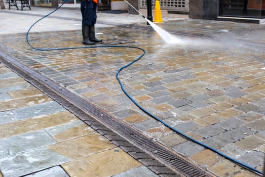 Urban cleaning service operator with high pressure gun. Selective focus