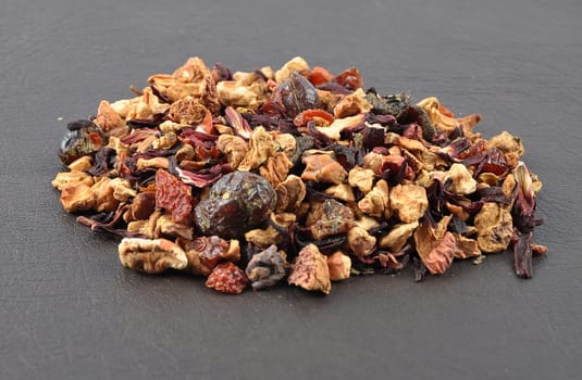 Loose fruit tea on a dark background
