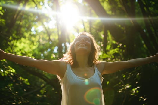 Happy woman with outstretched arms enjoy the sun in a green forest