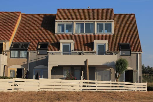A little beige house with blue sky in the background