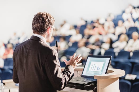 Speaker at Business Conference with Public Presentations. Audience at the conference hall. Entrepreneurship club. Rear view. Horisontal composition. Background blur.
