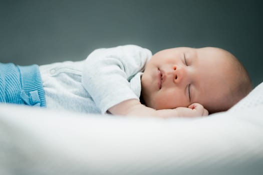Close-up portrait of adorable baby boy sleeping in bed, 1 year old baby concept