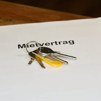 Keys and german rental contract, Mietvertrag, for a new apartment are on a table