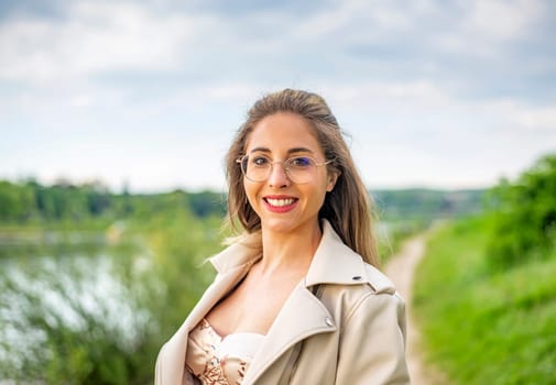 young woman with glasses standing on a meadow