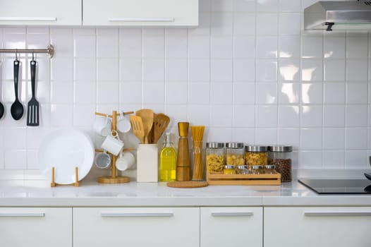 Kitchen utensils on white countertop, stove culinary background, wooden and white ceramic kitchenware. Home healthy cooking concept