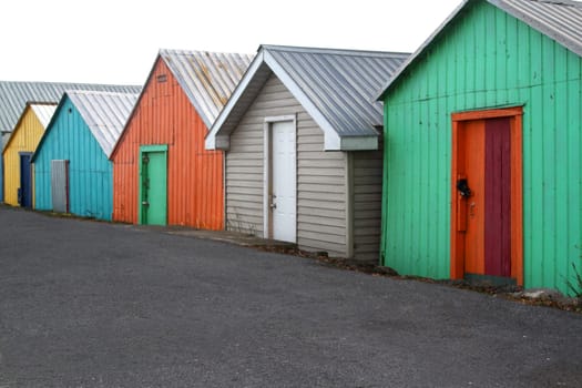 Colorful wooden boathouses used for storage of boats on lane