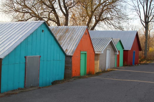 Colorful wooden boathouses used for storage of boats on lane