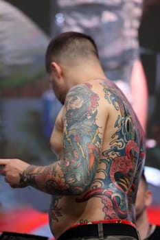 Krakow, Poland - June 11, 2022: Unidentified participant during the contest for the best tattoo at the 15th Tattoofest Convention in Cracow. One of the most prestigious tattoo festivals.