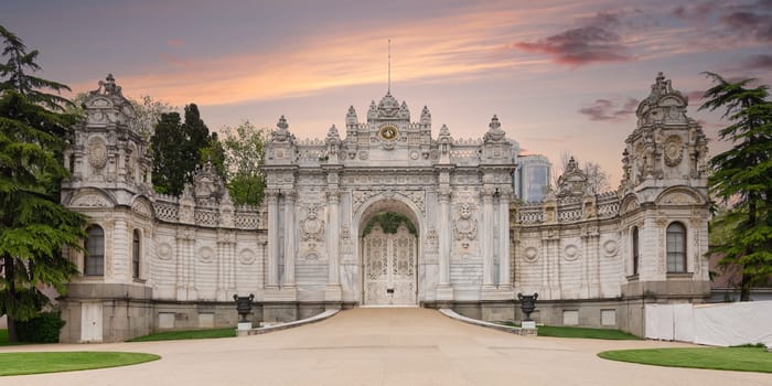 Sunset shot of closed gate leading to former Ottoman Dolmabahce Palace, or Dolmabahce Sarayi, suited in Ciragan Street, Besiktas district, Istanbul, Turkey. View from the internal court