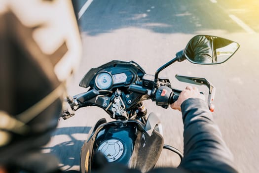 Close up of motorcyclist driving his motorbike on the street. View of hands of biker driving his motorbike