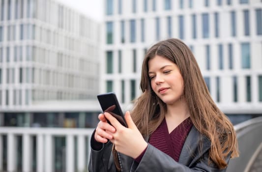 happy young woman with smartphone in the city