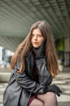 smiling young woman with black coat in the city