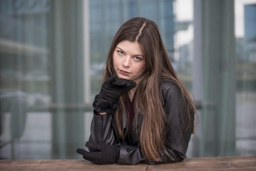 confident young woman with  black coat in the city