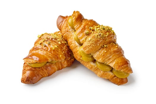 Indulge in flaky perfection with two pistachio cream croissants. the buttery layers and nutty filling create an irresistible, gourmet treat. ideal for showcasing french pastry artistry, this image captures the essence of quality, freshness, and indulgence