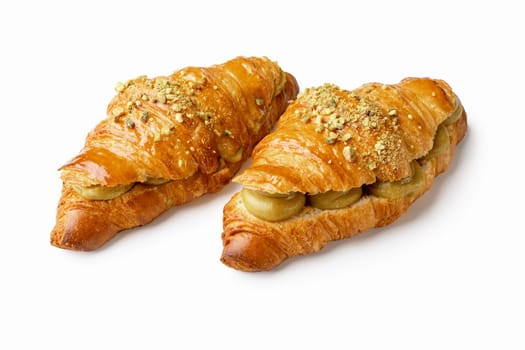 Indulge in flaky perfection with two pistachio cream croissants. the buttery layers and nutty filling create an irresistible, gourmet treat. ideal for showcasing french pastry artistry, this image captures the essence of quality, freshness, and indulgence