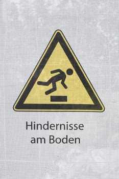 Yellow warning sign Stolpergefahr, obstacles on the ground, Germany