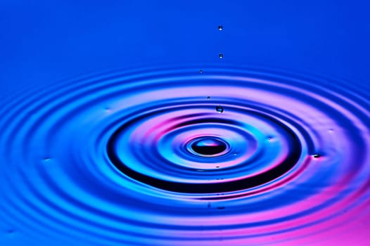 a drop of water falling into the water and creating waves. High quality photo