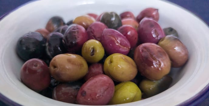 Ceramic bowl filled with cut pickled olives. Traditional method with the purpose of naturally eliminating the bitterness